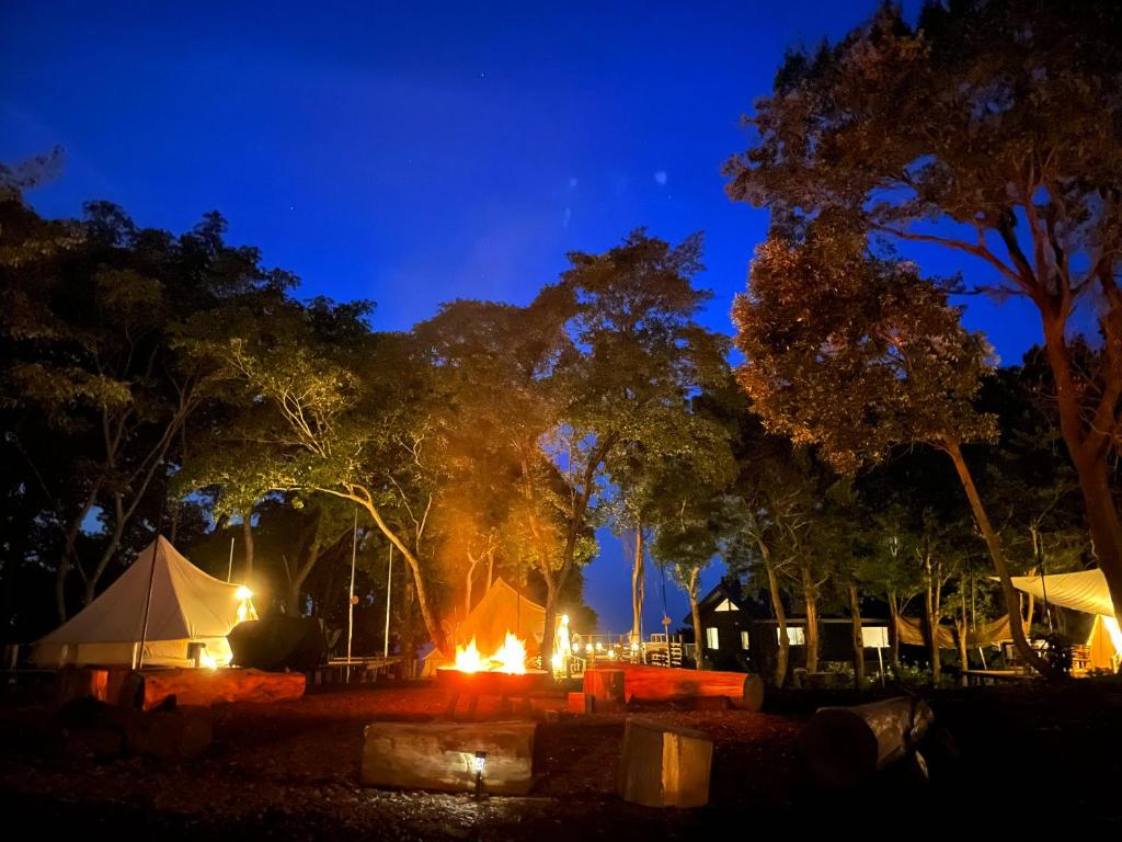 真鹤町COUSCOUS Glamping Manazuru的夜间公园里的帐篷和火