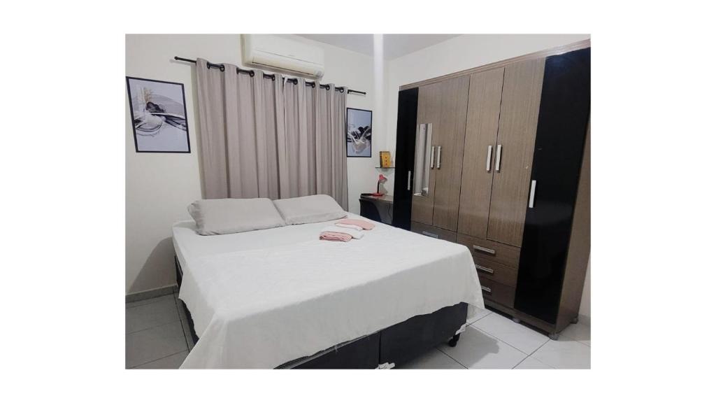 彼得罗利纳Apê Térreo, próximo ao Shopping!的卧室配有白色的床和木制橱柜。