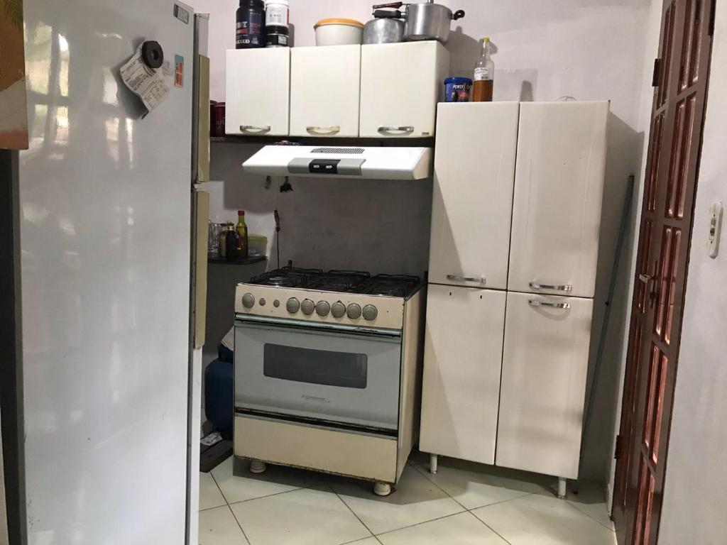 马拉塔伊济斯Casa B: Belo Horizonte Marataízes的厨房配有炉灶和冰箱。