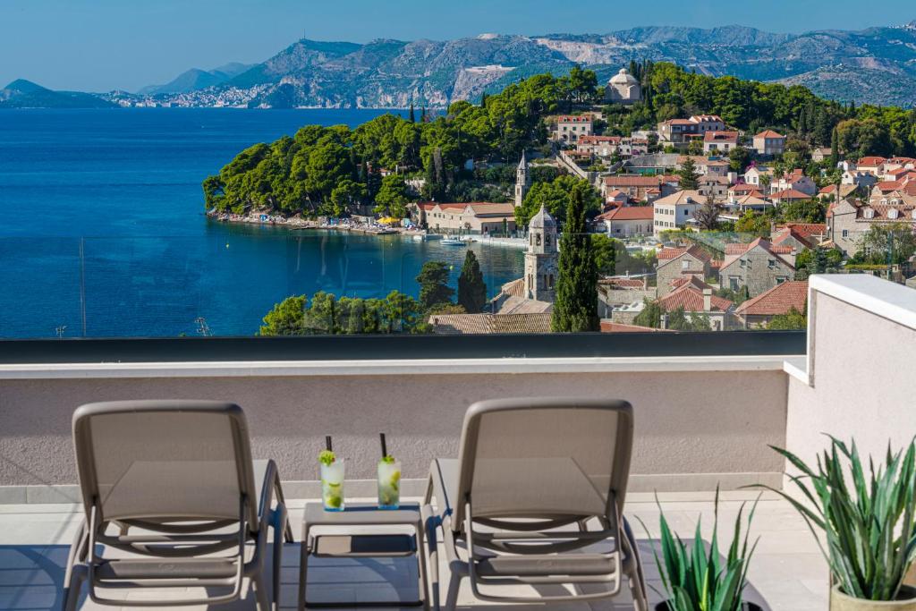 察夫塔特"Villa AnMari" The Cavtat View Residence的阳台配有桌椅,享有水景