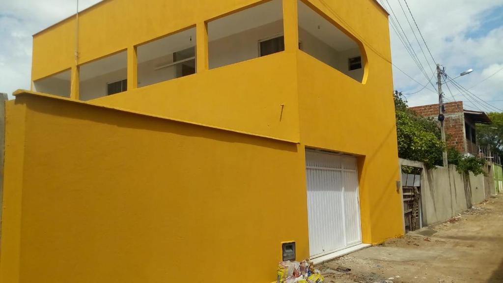 南蒂包casa pra muito gente的黄色建筑,带有白色车库