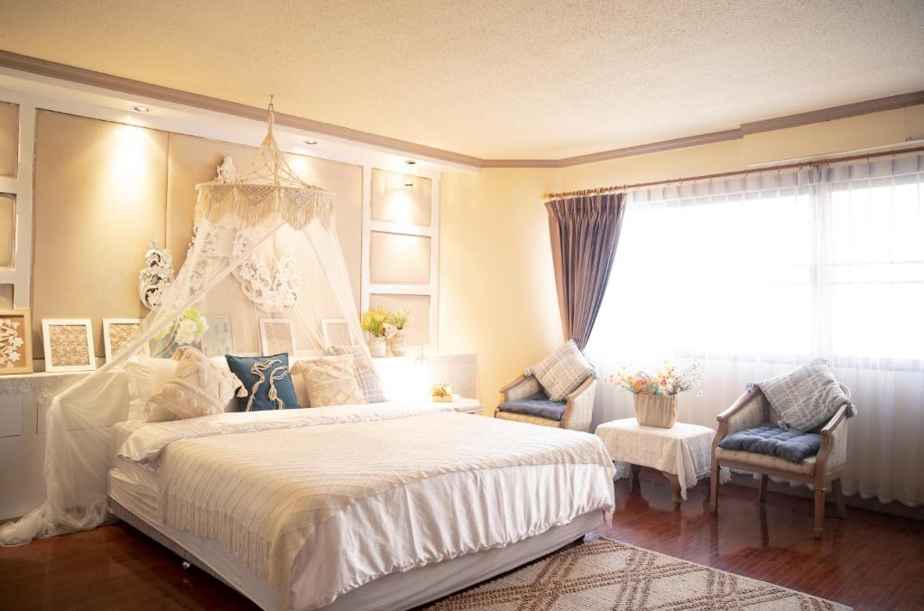 清迈Secret garden的卧室设有一张白色大床和一扇窗户。