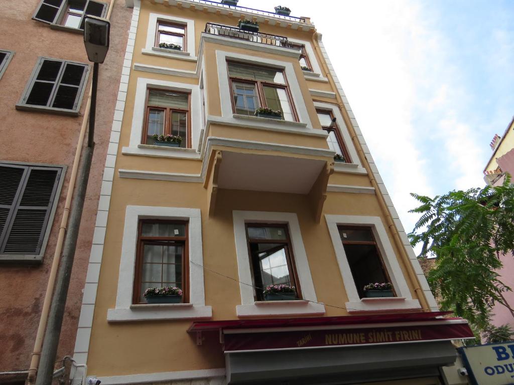 伊斯坦布尔Emin Cami Sokak No13的城市街道上一座黄色建筑,设有窗户