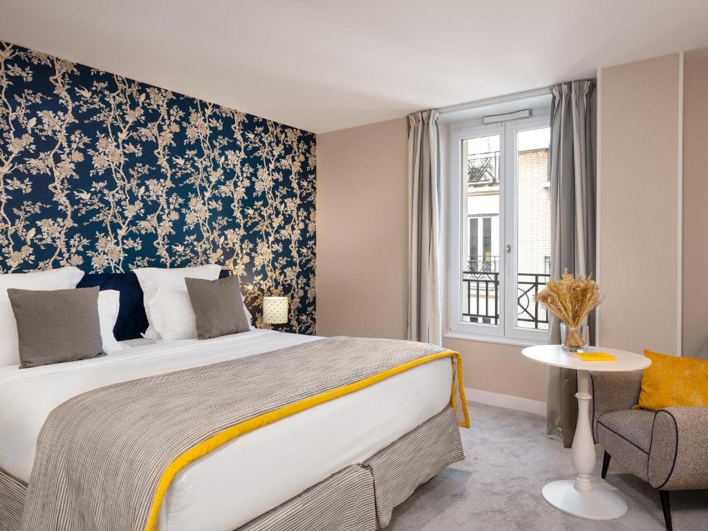 巴黎勒马伊尔酒店的一间卧室配有一张大床和一把椅子