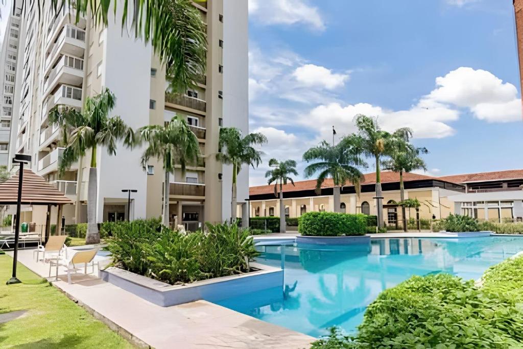 阿雷格里港Apartamento Espaçoso & Aconchegante - 3 quartos的一座棕榈树游泳池和一座建筑