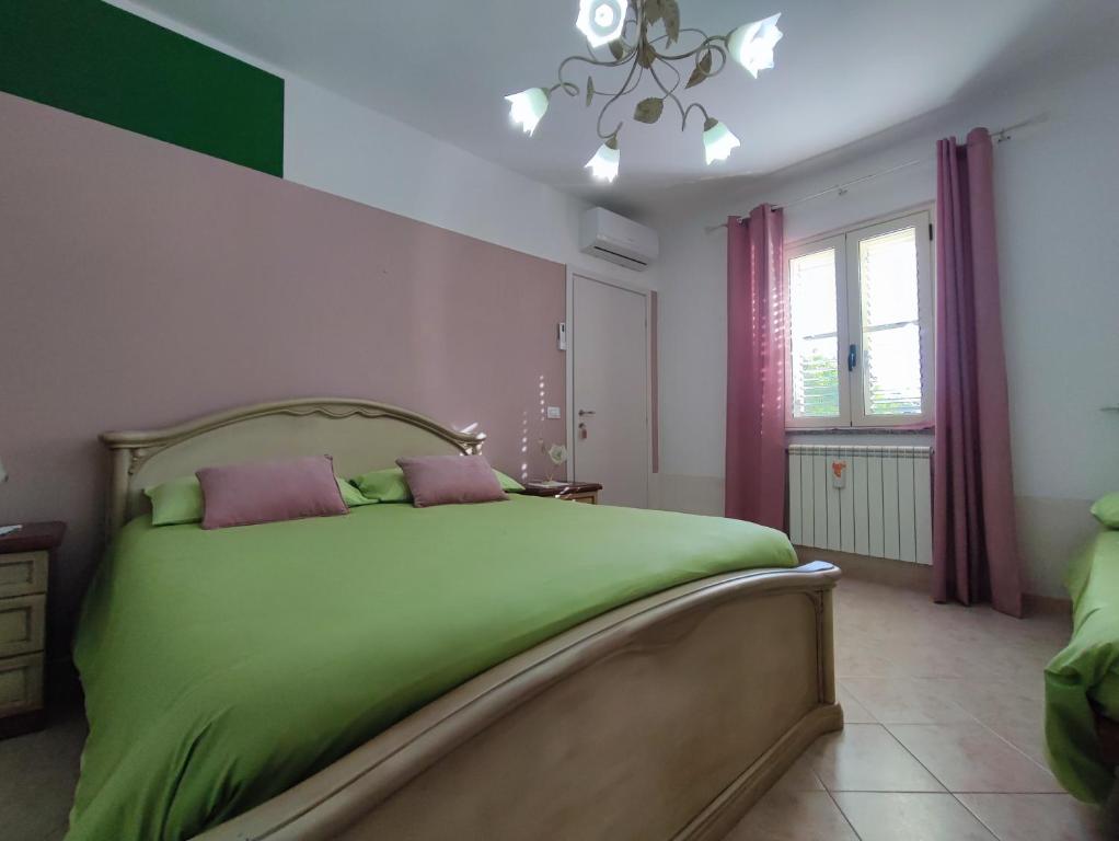 圣欧费米亚拉默齐亚Casetta GGG的一间卧室配有带两个枕头的绿色床