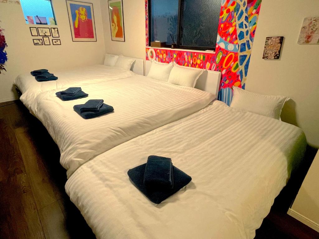 大阪ART HOUSE-アートハウス友家tomoya-的客房内的两张床和毛巾