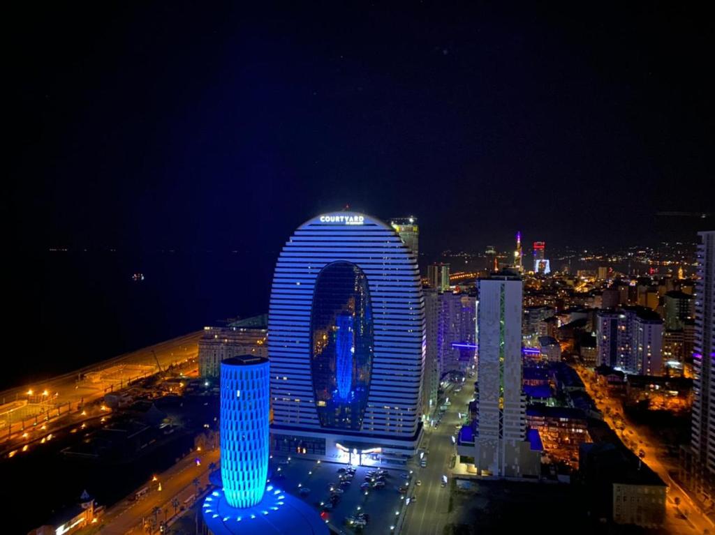 巴统Orbi City Batumi Hotel的享有带蓝色灯光的大型建筑的夜景