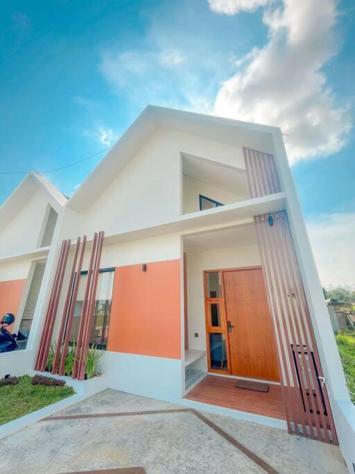 斯勒曼Villa Kamar Tamu Balecatur 2的前面有橙色门的白色房子