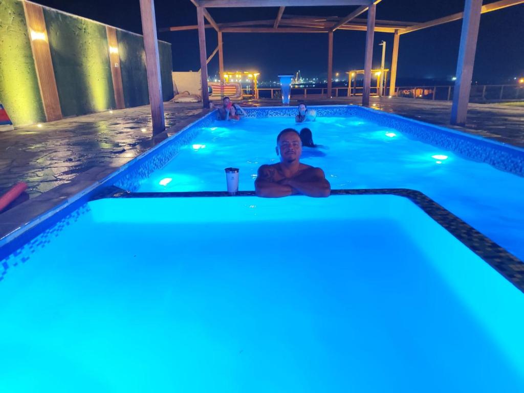 因比图巴Chale vista do Porto Imbituba com piscina的夜晚坐在游泳池里的人
