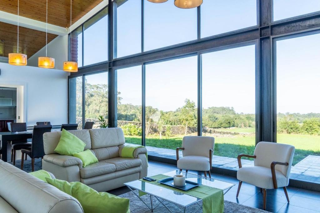 Pico da PedraBatalha Golf Villa的带沙发、椅子和窗户的客厅