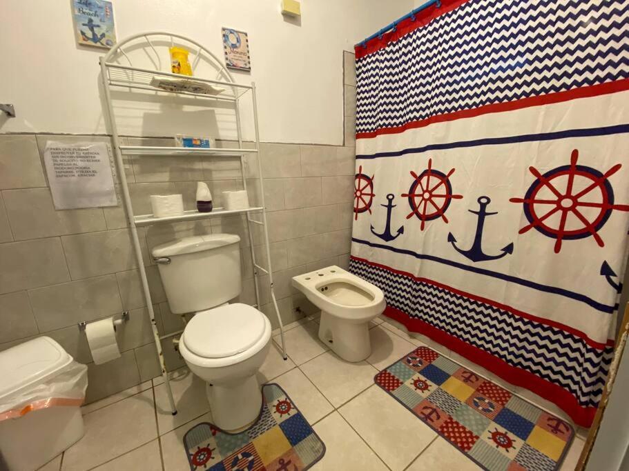 卡沃罗霍Villa Retiro R in Boquerón Area的浴室设有卫生间和悬挂美国国旗的淋浴帘。