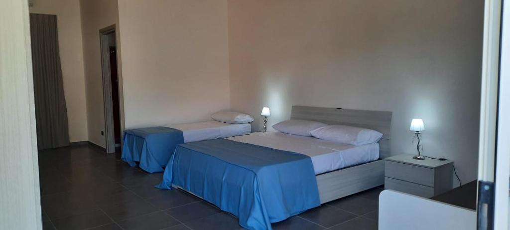 比亚恩科Villaggio Jonio Blu的酒店客房设有两张床和两盏灯。