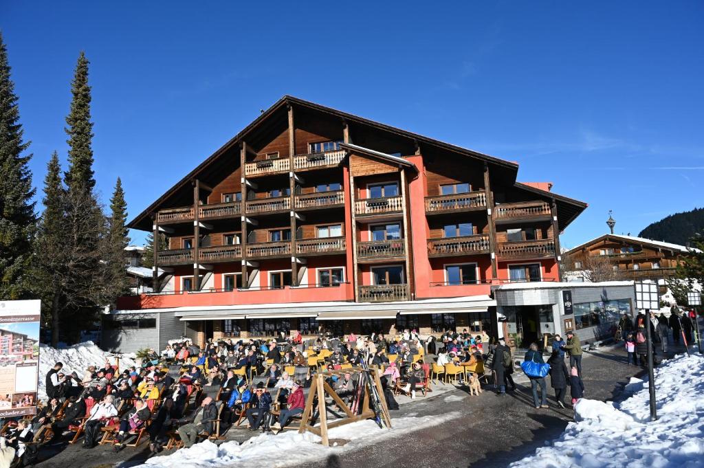蒂罗尔-泽费尔德鸿扯德酒店的一群人站在滑雪小屋前