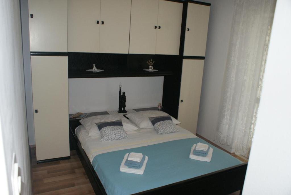 科尔丘拉Korčula Guest House的一间卧室配有一张带白色橱柜的床。