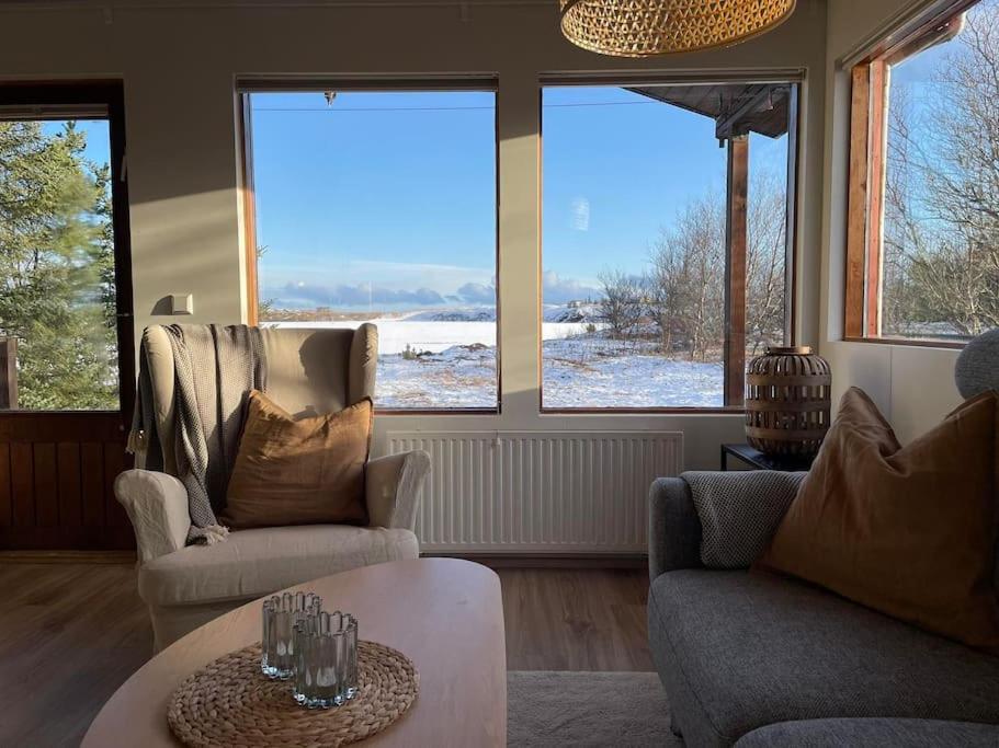 教堂城Lakeview cabin near Kirkjubaejarklaustur的客厅配有两把椅子和一张桌子,窗户