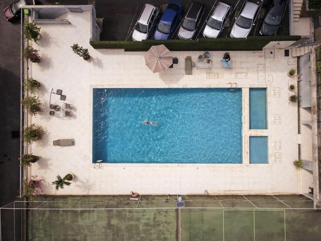 阿比让Résidences Les Hauts de l'Indenié的游泳池的顶部景色,有人在游泳池游泳