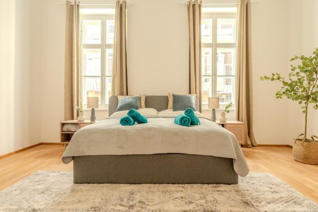 多瑙河畔克雷姆斯Deluxe Apartments near the center的一间卧室配有一张大床和两个蓝色枕头