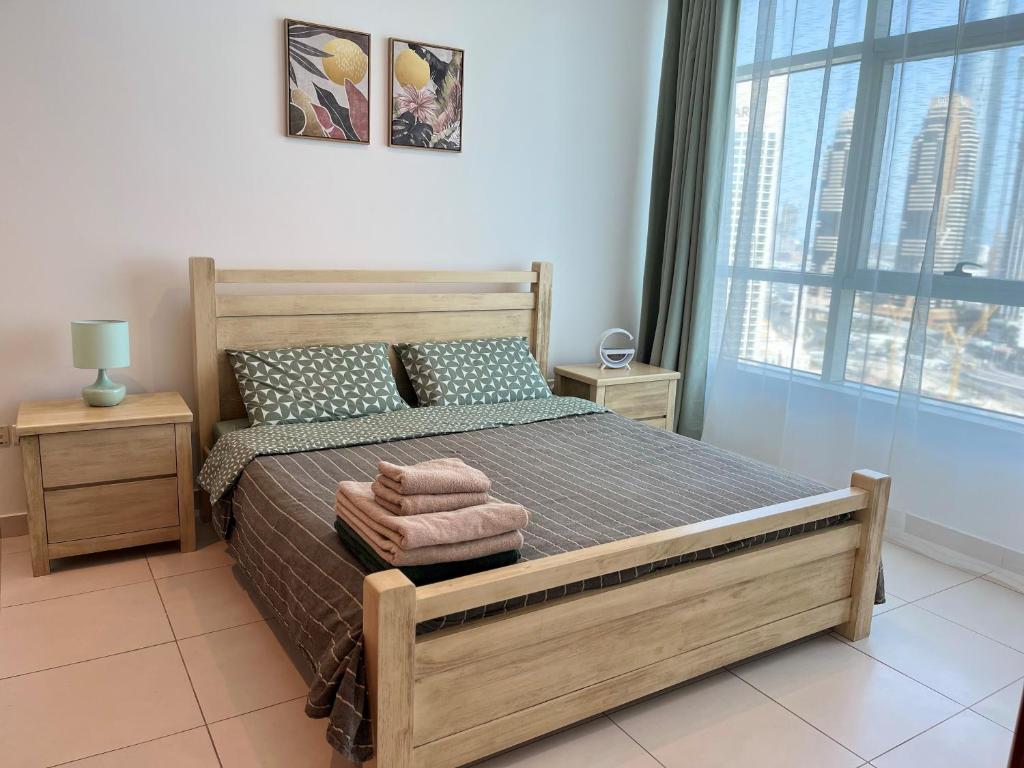 迪拜Amazing 1 bedroom apt in Marina的一间卧室设有一张床和一个大窗户