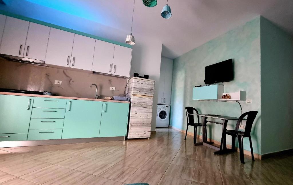 伏罗拉Diego Rooms Vlora的厨房配有桌椅和电视。
