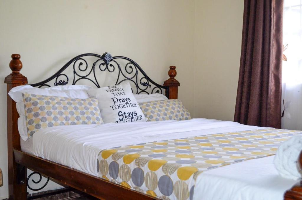 埃尔多雷特ELDORET STAYS的一间卧室配有一张带木制床头板和枕头的床。