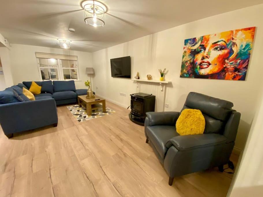 卡斯莱兰Modern family home的客厅配有2张蓝色沙发和一幅画