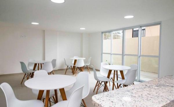 萨尔瓦多Jaguaribe Praia的一间设有白色桌子和白色椅子的房间