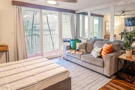 拉耶Beachfront Condo with AC的带沙发和大窗户的客厅