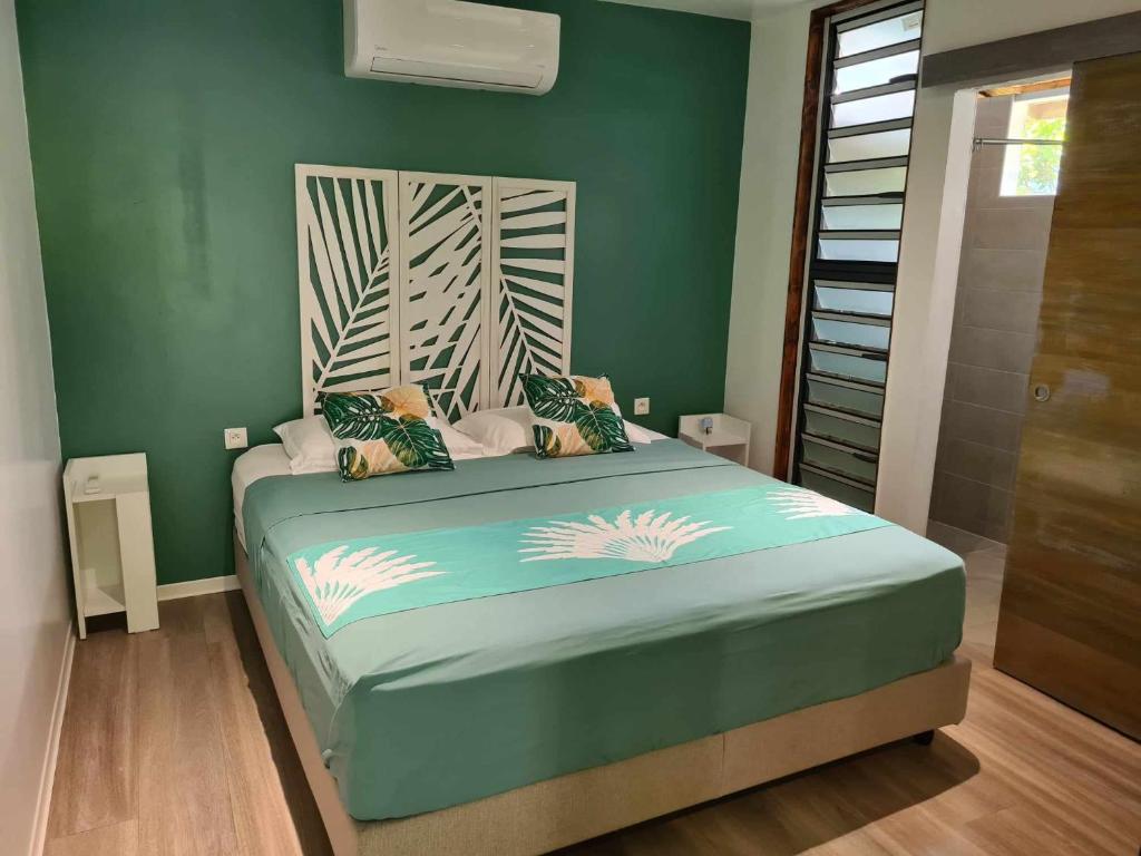 TohautuFare Miti-Rapa的一间卧室配有一张带绿色墙壁的床