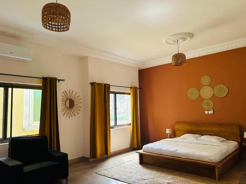 科托努Cocoon Guest House的卧室配有床、椅子和窗户。
