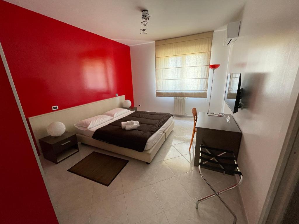 卡利亚里埃利亚的住宿加早餐酒店的卧室设有红色的墙壁、一张床和一张桌子