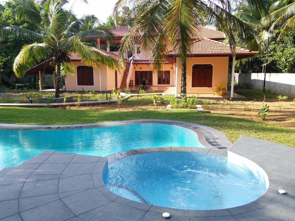 哈巴拉杜瓦金椰子酒店的房屋前的游泳池