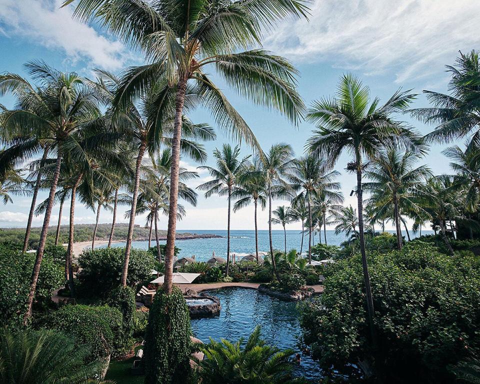 拉奈城拉奈岛四季度假酒店的拥有游泳池、棕榈树和海洋的度假胜地