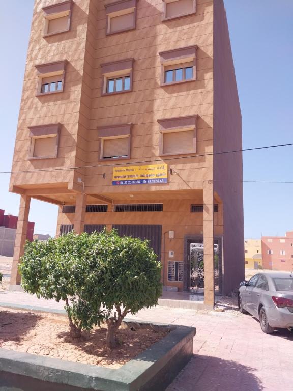 Cabo BojadorRésidence Mayssa 1 et Mayssa 2 boujdour appartements meublés的前面有棵树的建筑