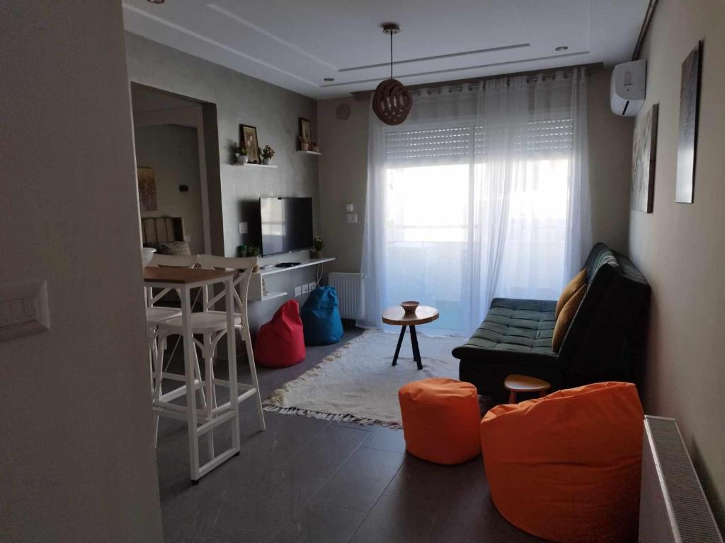 Boumhel El BassatineCoquette Appartement的带沙发的小客厅和厨房