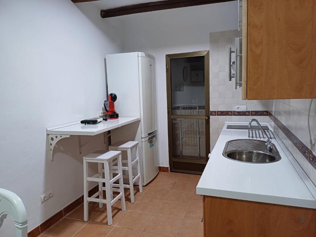 隆达La casita Ronda的厨房配有水槽和白色冰箱