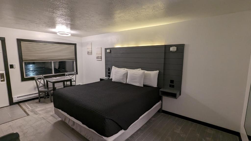 萨利纳High Desert Inn的一间卧室配有一张床、一张书桌和一个窗户。