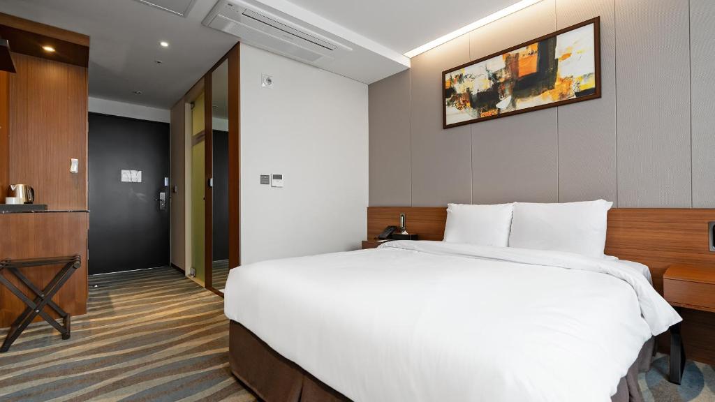 全州市Gloucester Hotel Jeonju的酒店客房设有一张大床和一台电视。