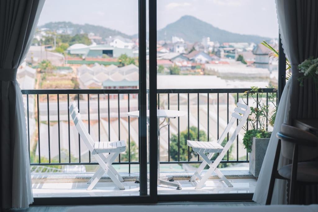 大叻Canary Dalat Hotel的美景阳台配有两把椅子和一张桌子