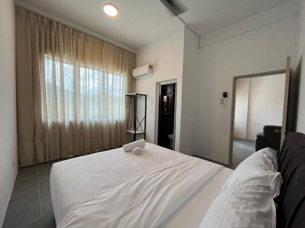瓜埠Level 4 Simfoni Beliza的窗户客房内的一张白色床