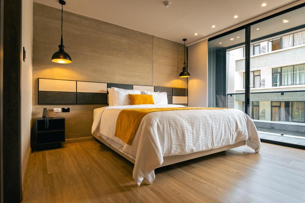 佩雷拉Balmoral Plaza Hotel的一间卧室设有一张大床和一个大窗户