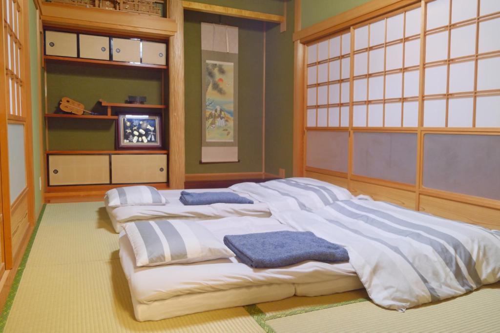 四万十市四万十川傍にある日本家屋まるごと「貸切宿　ほとり」的一间设有四张白色大床的房间