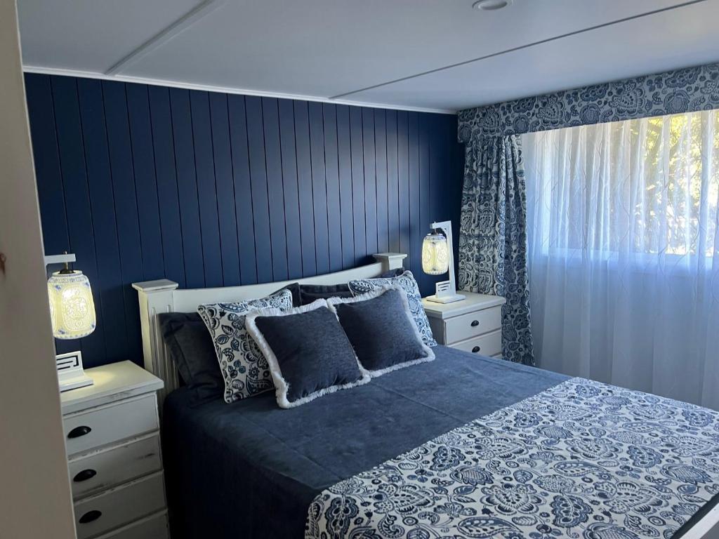 雷德克利夫Rainbows End的一间卧室拥有蓝色的墙壁,配有一张带枕头的床。