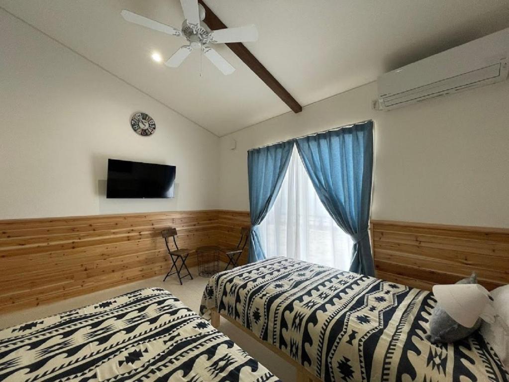 鸟取市Pension Le Passage - Vacation STAY 11300v的一间卧室设有两张床和一个带吊扇的窗户。