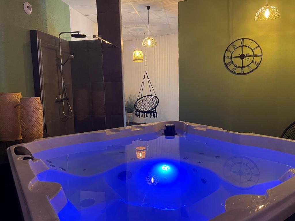 NébouzatLogis Hôtel Volcan Sancy的带淋浴的浴室内的大蓝色浴缸