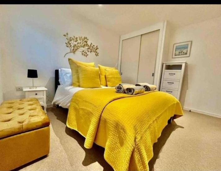布里斯托Gorgeous apartment with free parking & breakfast near city centre & midday checkout的一间卧室配有黄色的床和黄色的毯子
