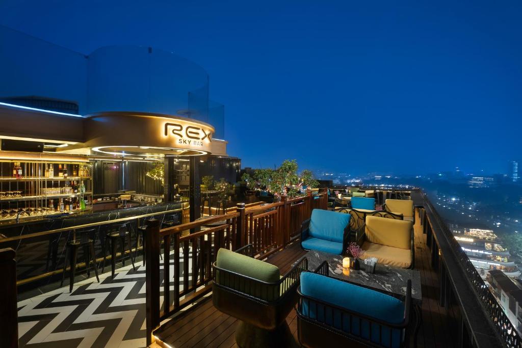 河内Rex Hanoi Hotel的屋顶酒吧设有椅子,享有城市美景