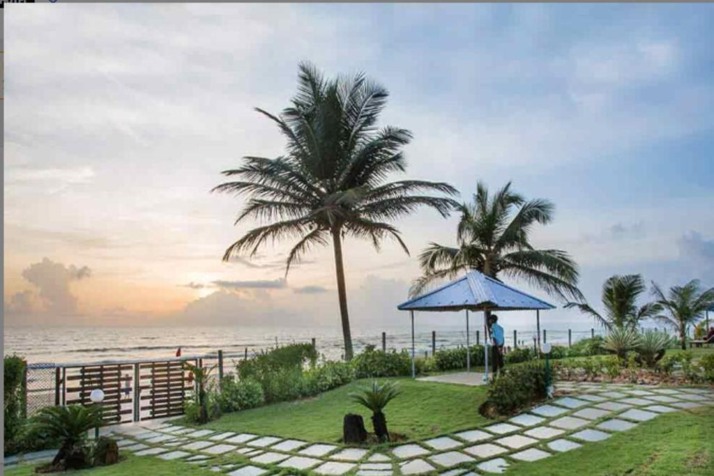 比纳里姆Beach House Resort Goa的站在海滩附近的伞下的人