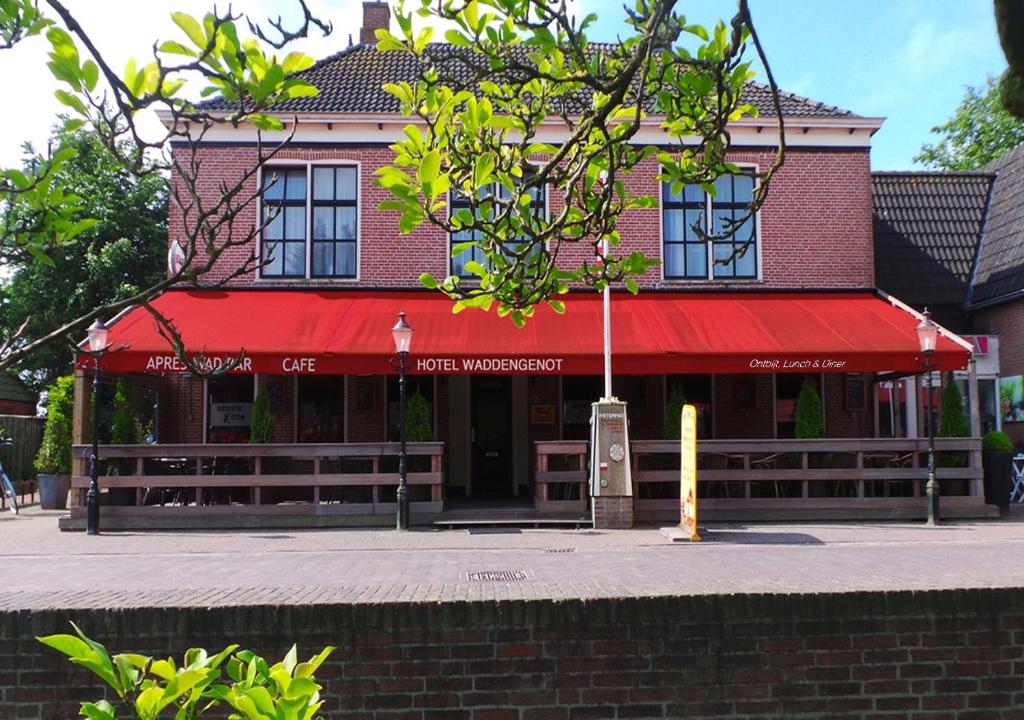 彼得比伦Hotel Waddengenot的街上有红色遮阳篷的建筑