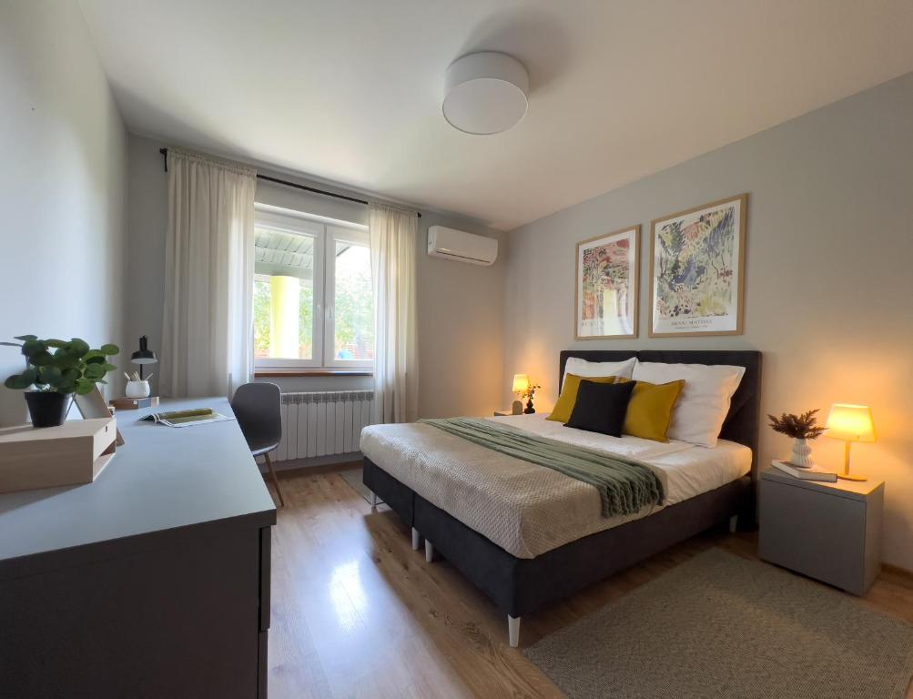 JasionkaGarden House - OSTOYA的一间卧室配有一张床和一张带两盏灯的书桌。